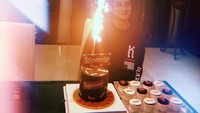 Dapat kejutan ulang tahun yang manis dari keluarganya. Elroy tersenyum senang, saat berpose di hadapan kue berlogo Supreme lengkap dengan mini cucpake di sampingnya. Foto: Instagram @elroxcheo