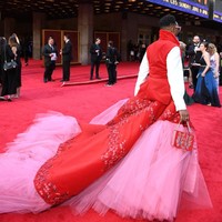 Setelan tuksedonya dibuat feminin dengan tambahan train panjang berhias tulle pink dan detail embroidery di atasnya. Gaunnya dirancang oleh Celestino Couture. Foto: Getty Images
