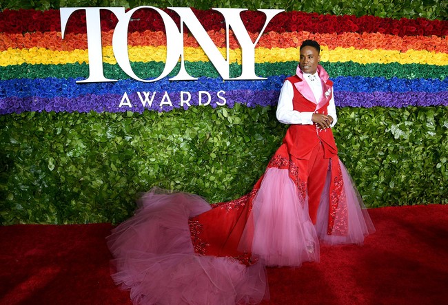 Penampilan aktor Billy Porter menjadi sorotan saat menghadiri Tony Awards 2019, lantaran ia mengenakan setelan tuksedo yang  dibuat feminin dengan tambahan train panjang berhias tulle pink dan detail embroidery di atasnya. Gaunnya tersebut jadi kontroversial.  Foto: Getty Images