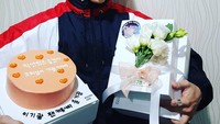 Dapat kejutan manis, Gikwang pasang pose keren dengan kue bernuansa merah muda dan sekotak hadiah untuknya. Foto: Instagram @gttk0000