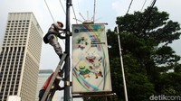Neon box tersebut menempel dengan tiang lampu.