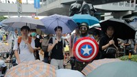 Seorang demonstran memakai tameng Kapten Amerika. REUTERS/Thomas Peter.