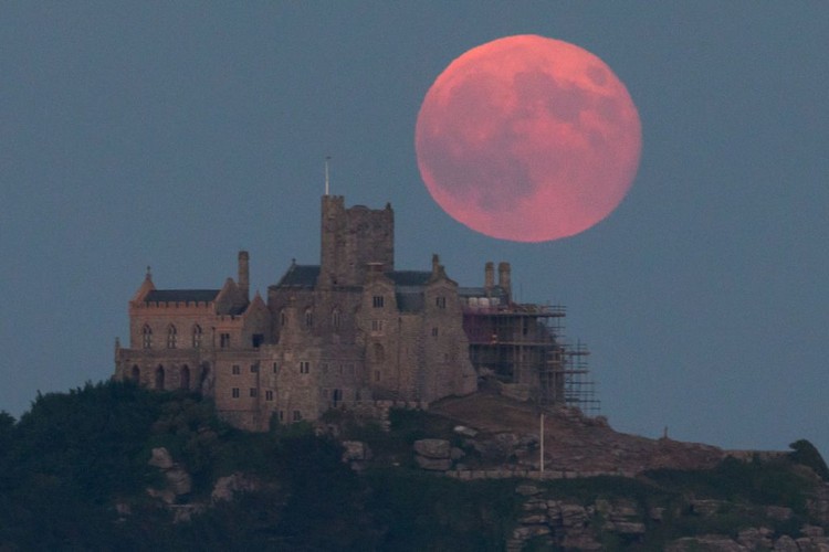 MARAZION, ENGLAND - JUNE 28:  A full moon rises behind St Michaels Mount in Marazion near Penzance on June 28, 2018 in Cornwall, England. Tonights strawberry moon, a name given to the full moon in June by Native Americans because it coincides with strawberry picking season, comes as parts of the UK continue to experience heatwave weather and record breaking temperatures. (Photo by Matt Cardy/Getty Images)