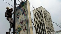 Petugas dari Sudin Perindustrian dan Energi DKI Jakarta menurunkan neon box yang berjejer di kawasan Senayan.
