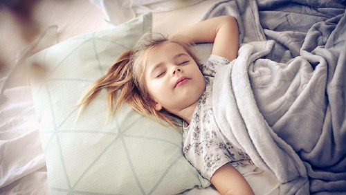 Calm middle-aged woman is sleeping on bed with pleasure