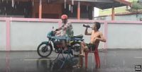 Hujan Deras, Pria Ini Lanjut Makan Mie dan Minum di Tengah Jalan