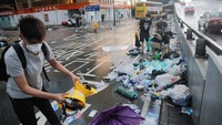 Sejumlah warga Hong Kong nampak membersihkan sampah yang berserakan di jalan usai melakukan aksi protes terhadap Rancangan Undang-undang (RUU) ekstradisi. Thomas Peter/Reuters.