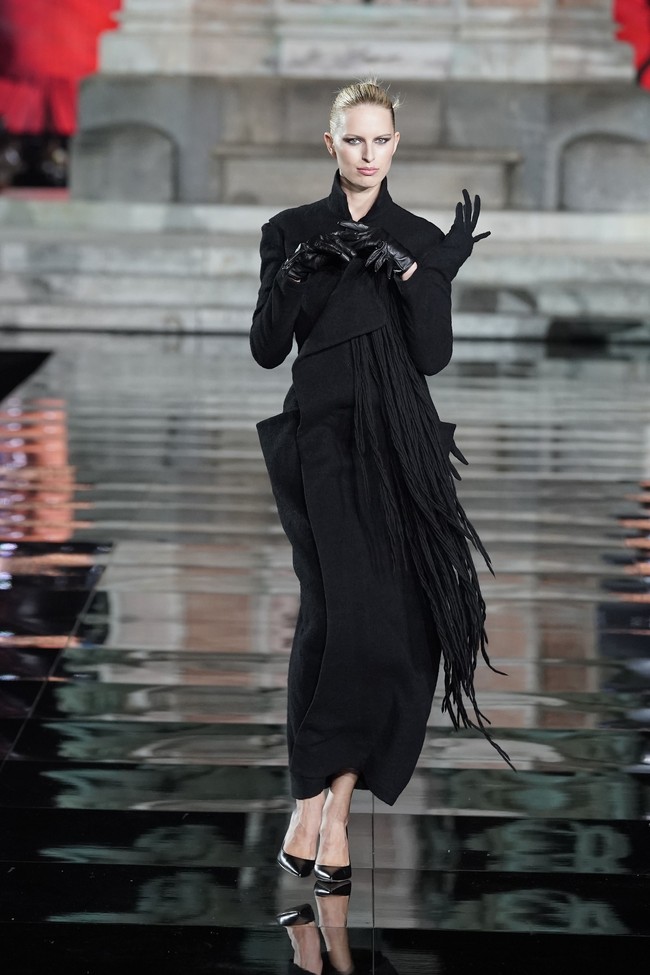 Tidak ketinggalan model Karolina Kurkova. Tubuhnya dibalut gaun hitam bergaya coat yang dihiasi detail rumbai nan unik. (Foto: Getty Images)