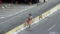 Seorang warga melintas diantara kawat berduri di depan gedung Mahkamah Konstitusi, Jakarta, Jumat (14/6/2019).
