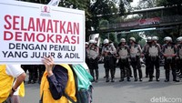 Seorang peserta aksi membawa poster bertuliskan Selamatkan Demokrasi Dengan Pemilu Yang Jujur & Adil saat melakukan aksi di kawasan Patung Kuda.