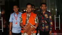Rommy tampak memakai rompi tahanan dan mambawa map.