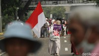 Seorang massa juga terlihat membawa bendera Merah Putih.