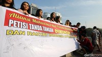 Mereka membentangkan spanduk bertuliskan Petisi Tanda Tangan Dukungan Dari Mahasiswa dan Rakyat Indonesia Untuk TNI-Polri.