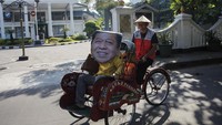 Seorang warga menggunakan topeng wajah Setya Novanto menaiki becak saat melakukan aksi parodi plesiran Setya Novanto, Solo, Senin (17/6/2019).