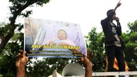 Mereka membawa foto aparat yang terluka akibat peristiwa tersebut.