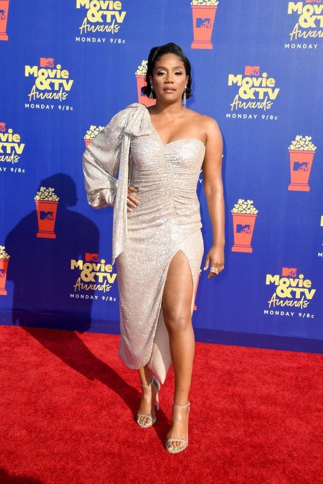 Gaun krem dengan bahu menjadi andalan aktris dan komedian Tiffany Haddish. Gaun tersebut mengakomodasi aura seksi sang aktris berkat belahan tinggi pada bagian rok. (Foto: Frazer Harrison/Getty Images for MTV)