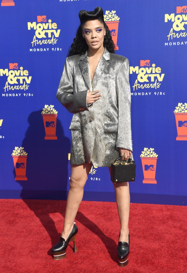 Menghadiri MTV Movie & TV Awards 2019, Tessa Thompson hanya membungkus tubuhnya dengan dress bergaya oversized blazer perak yang mengilap dari Thom Browne. Belahan dada yang rendah semakin mempertegas kesan seksi. (Foto: Getty Images)