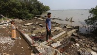 Seorang warga berdiri di antara puing-puing bangunan yang rusak akibat dihantam abrasi di Kampung Muara Jaya, Desa Pantai Mekar, Muara Gembong, Kabupaten Bekasi, Jawa Barat, Senin (17/6/2019).
