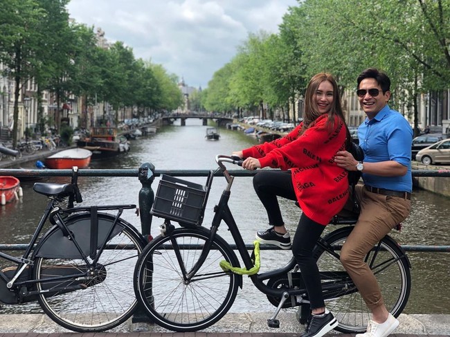 Berpose naik sepeda dengan latar belakang kanal wajib dilakukan saat di Amsterdam. Ayu Tingting pun melakukannya dengan ditemani seorang temannya. Bergaya naik sepeda, Ayu terlihat memakai sweater merah dari Balenciaga dan sneakers Hermes. Foto: Instagram @ayutingting92