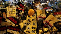 Karangan bunga dan berbagai benda lainnya nampak memenuhi lokasi jatuhnya sang demonstran yang tewas saat ikut serta melakukan aksi unjuk rasa memprotes RUU ekstradisi. Tyrone Siu/Reuters.