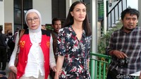 Atiqah nampak mengenakan dress bermotif floral dan membawa tas berwarna ungu saat hadir dalam sidang lanjutan Ratna Sarumpaet.