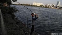 Seorang pengunjung sedang memancing di kawasan danau.
