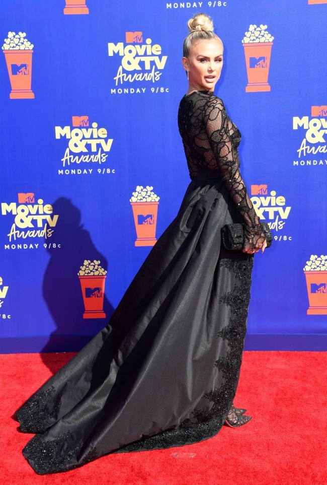 Sepatunya juga senada dengan celana sehingga tampak menyatu. Tidak ketinggalan clutch hitam dan rambut bergaya top-knot turut menyempurnakan gaya perempuan 29 tahun ini. (Foto: Getty Images)