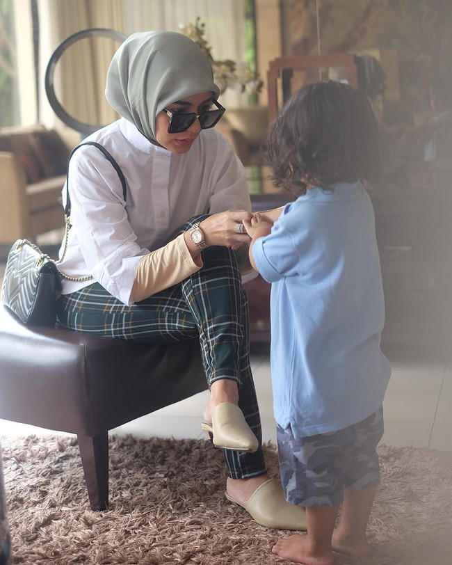 Meisya mencoba memaksimalkan penampilan barunya berhijab dengan tetap memakai busana yang sebelumnya dia miliki. Untuk menyiasatinya, pada foto ini misalnya di mana dia memakai kemeja putih lengan pendek, ibu tiga anak itu menambahkan manset warna kulit. Foto: Instagram @ meisya__siregar