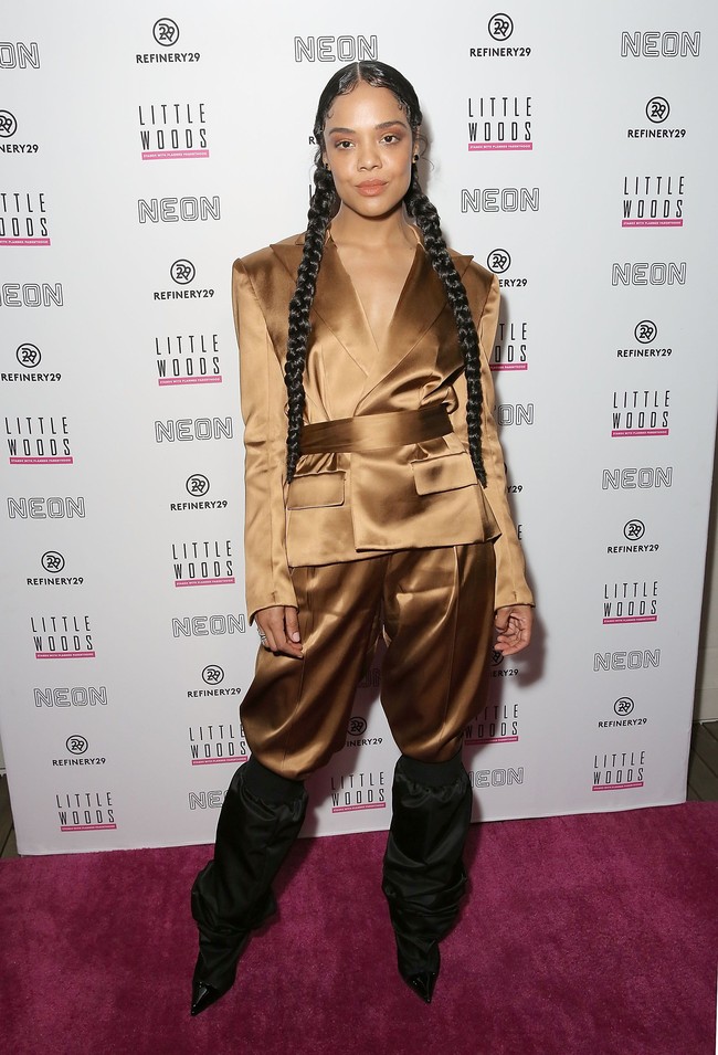 Sesekali, Tessa Thompson memilih sepatu sebagai fashion statement. Seperti oversized boots hitam yang dipadukannya dengans setelan satin coklat ini. (Foto: Getty Images)