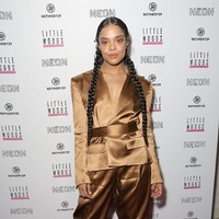 Sesekali, Tessa Thompson memilih sepatu sebagai fashion statement. Seperti oversized boots hitam yang dipadukannya dengans setelan satin coklat ini. (Foto: Getty Images)