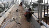 Sejumlah pekerja menyelesaikan pembangunan jembatan penyeberangan di atas Tol JORR 2 Kunciran-Serpong.
