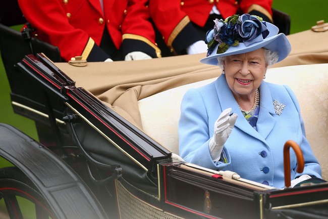 Ratu Elizabeth sebagai tuan rumah acara Royal Ascot tampil mencuri atensi dengan dress birunya. Ia juga memakai topi bunga senada untuk melengkapi penampilannya.  Foto: Getty Images