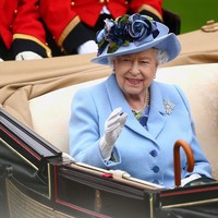 Ratu Elizabeth sebagai tuan rumah acara Royal Ascot tampil mencuri atensi dengan dress birunya. Ia juga memakai topi bunga senada untuk melengkapi penampilannya.  Foto: Getty Images
