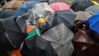 Dengan menggunakan payung mereka melindungi diri dari semprotan gas air mata yang dikeluarkan oleh polisi setempat. (Foto: Boredpanda)