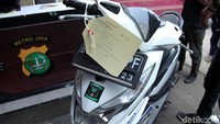 Sebuah motor turut ditampilkan sebagai barang bukti kasus penjambretan tersebut.