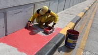 Seorang petugas nampak sibuk mengecat marka jalan di kawasan Underpass Tanah Abang, Jakarta.