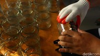 Perajin menunjukkan proses pemotongan botol tersebut.