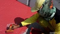 Seorang petugas mengecat marka jalan di kawasan Underpass Tanah Abang, Jakarta.
