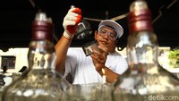 Perajin menunjukkan cara upcycling botol-botol bekas yang akan berubah fungsi menjadi barang-barang yang bermanfaat, seperti lampu dan tempat lilin.