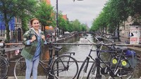 Gayanya berfoto di antara sepeda dan kanal yang ikonik di Belanda. (ayutingting92/Instagram)