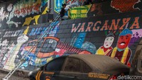 Komunitas Mural nampak asyik menghias dinding kolong tol di Pesanggrahan dengan mural bertemakan kota Jakarta.