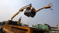 Alat berat juga dikerahkan untuk meratakan jalan yang ditambal.