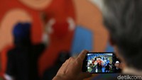 Seorang warga mengabadikan mural tersebut.