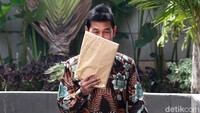 Ini momen saat Bupati Solok Selatan, Muzni Zakaria, menutupi wajahnya dengan map berwarna coklat usai diperiksa KPK, Jumat (21/6/2019).