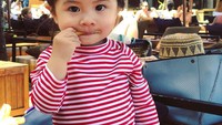Liburan ke Bali, Baby Chanco asyik nongkrong di pinggir pantai. Untuk ngemil, bayi imut ini pilih kentang goreng. Nyamm nyamm! Foto: Instagram babychanco