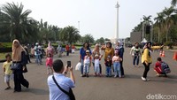 Sejumlah warga berwisata bersama keluarga ke Monumen Nasional (Monas), Jakarta, Sabtu (22/6/2019).
