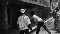 Sejumlah warga menyerang toko di salah satu kawasan di Jakarta imbas aksi G 30 S 1965. Carol Goldstein/Keystone/Getty Images.