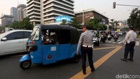 Sejumlah petugas lalu lintas nampak mengarahkan sejumlah kendaraan untuk menggunakan jalur lain karena adanya penutupan jalan di kawasan MH Thamrin.