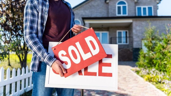 Sold house sign in Midwest suburban setting. Focus on sign.