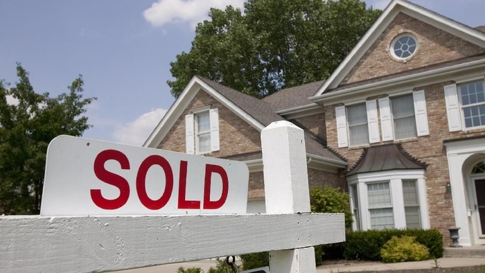 Sold house sign in Midwest suburban setting. Focus on sign.